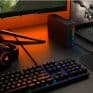 High-end gaming keyboard with RGB backlighting, gaming headset, and a computer setup with dual monitors, showcasing innovative and affordable technology solutions by InfoplayNet in South Africa.