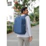 Backpacker with blue laptop bag on city street, modern urban lifestyle, showcasing durable travel gear and innovative backpack designs.