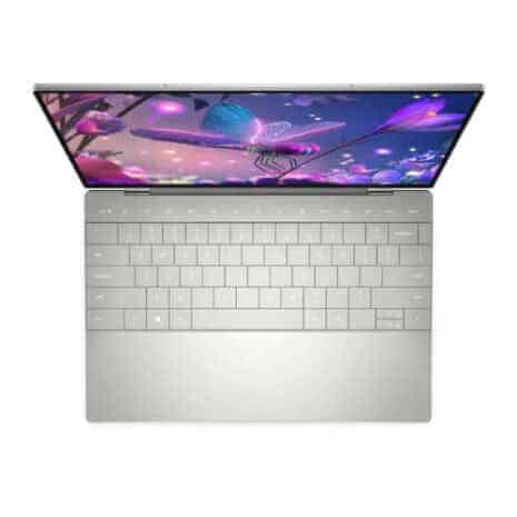 High-end silver laptop with a colorful, futuristic digital display showing neon-lit jellyfish and abstract underwater scenery, emphasizing technology and innovation.
