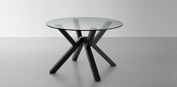 A round glass-top table with a modern black, crisscrossed base design.