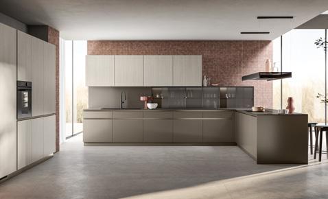 Modern kitchen with minimalist design, featuring sleek cabinets, a brick accent wall, built-in oven, and large windows.
