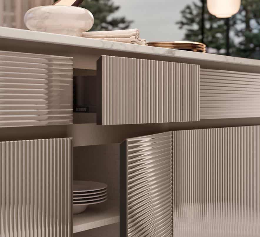 A close-up of kitchen cabinets with textured, horizontal line patterns and an open door revealing stacked plates inside. A marble countertop with decorative items is visible on top.