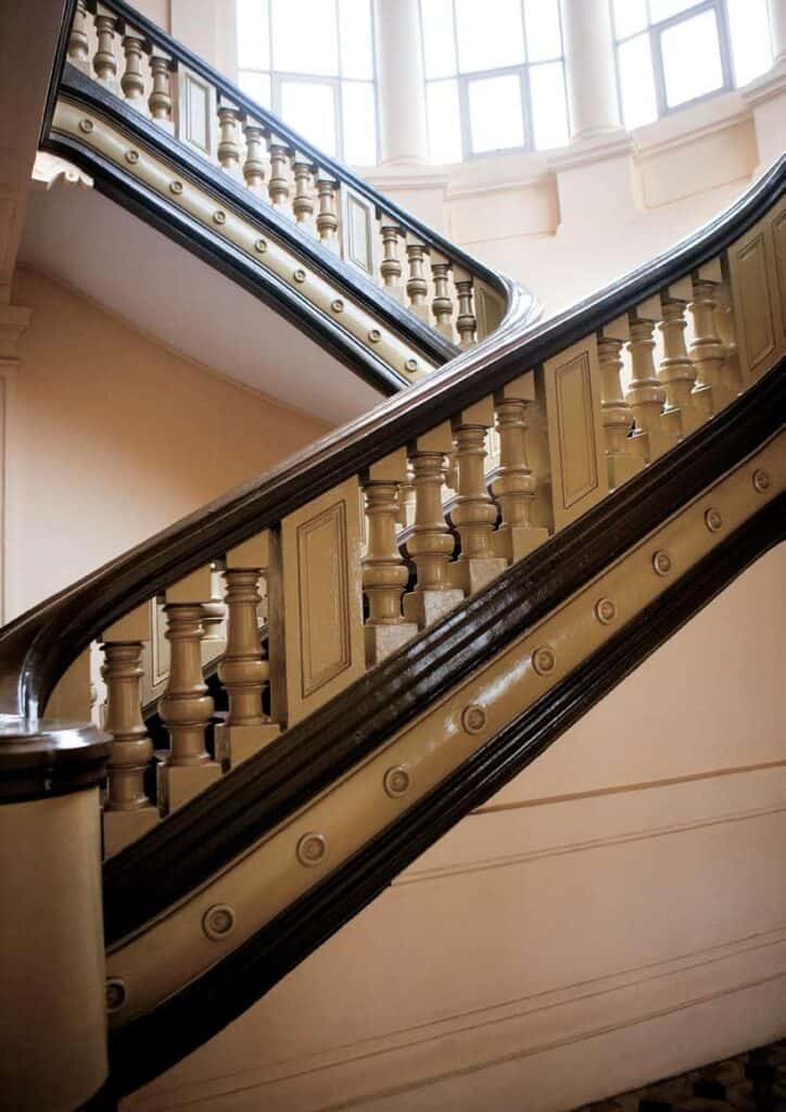Ornate wooden staircase with decorative balusters and handrails.