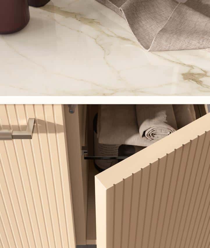 A beige cabinet with vertical grooves is partially open, revealing folded towels inside. A marble countertop is visible above with a brown container and a beige cloth.