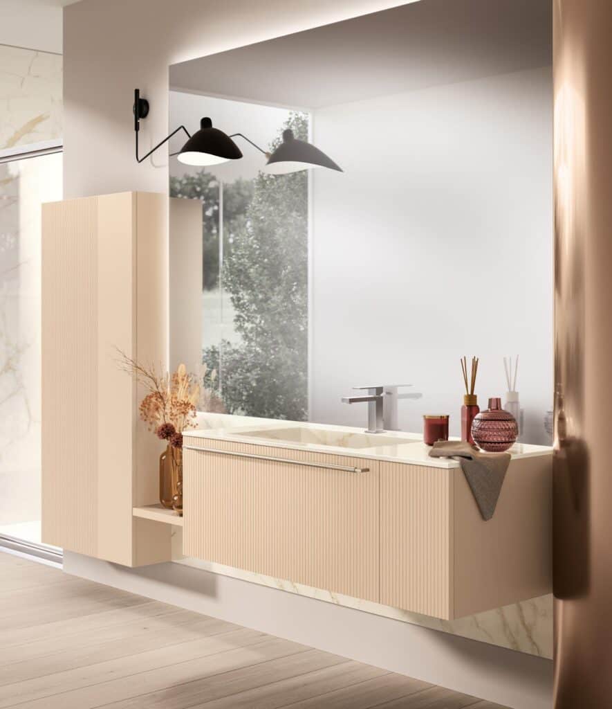 Modern bathroom with a beige floating vanity, large mirror, minimalist faucet, black wall-mounted lamp, and decorative vases.