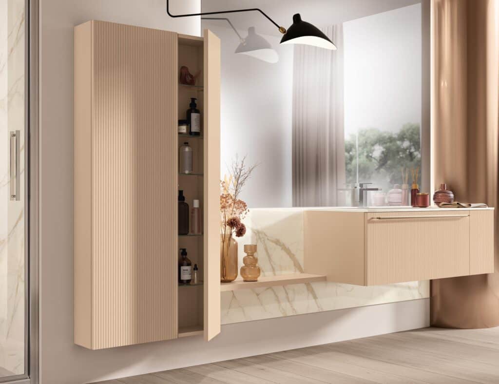 Modern bathroom with beige cabinetry, open shelves displaying toiletries, a marble backsplash, and a large wall mirror reflecting natural light through a window.