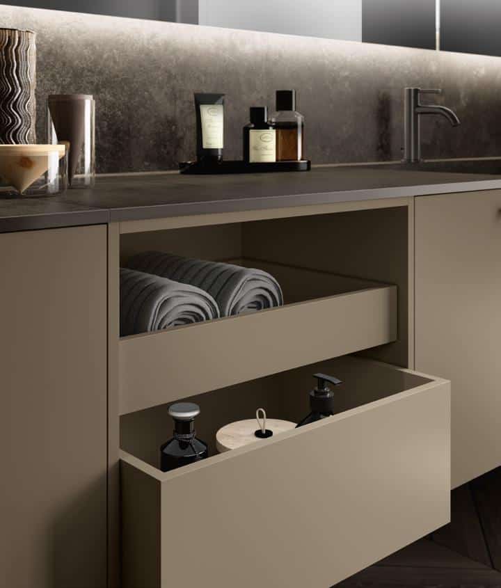 Bathroom vanity with open shelving displaying rolled towels and toiletries.