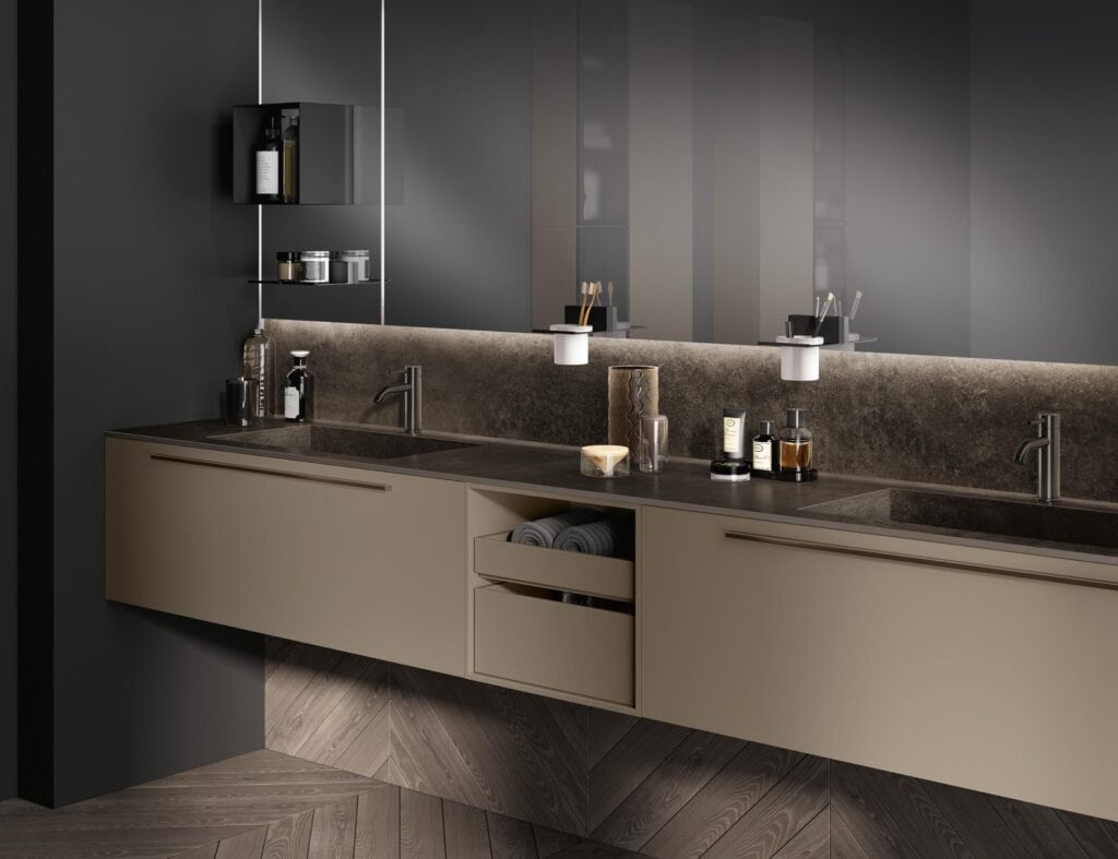 Modern bathroom with dark cabinets, dual sinks, and illuminated mirrors above.