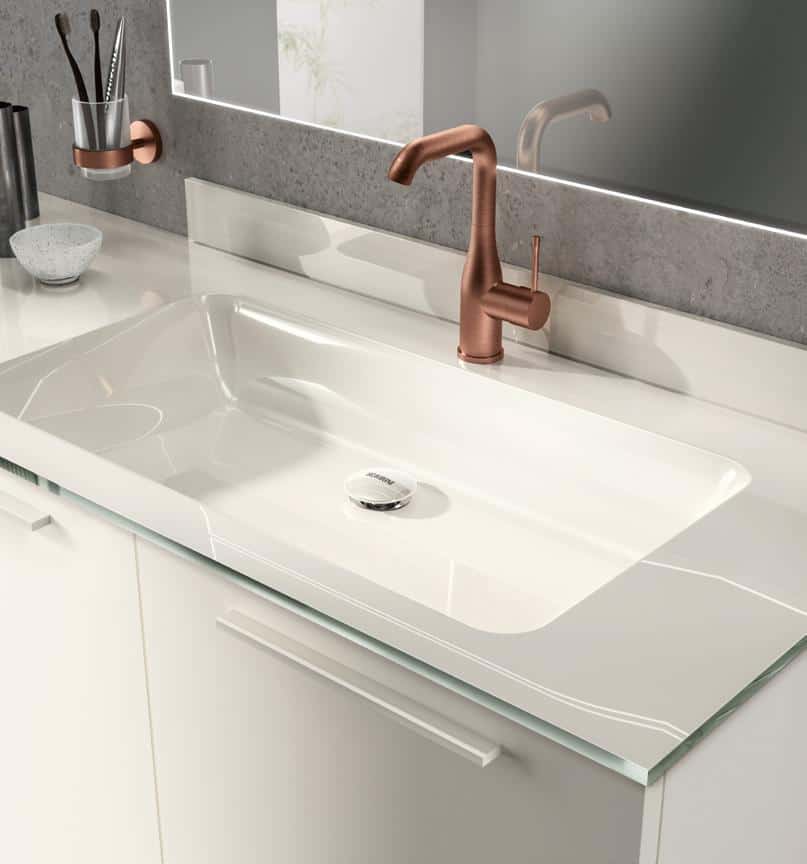 Modern bathroom sink with a white countertop, bronze faucet, and a wall-mounted toothbrush holder.