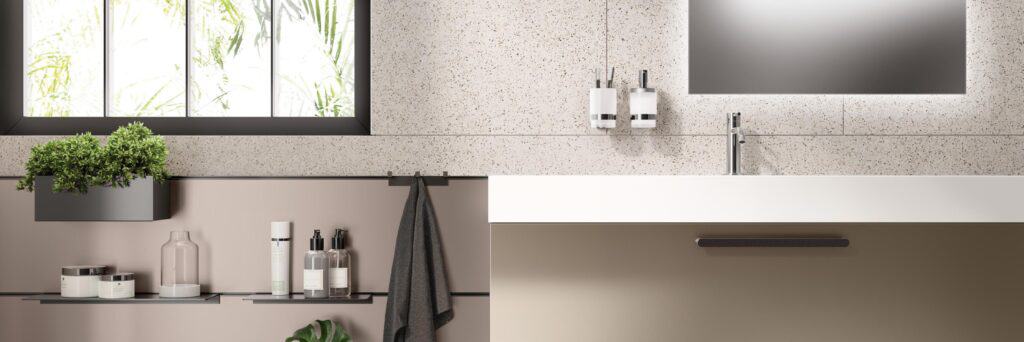 Modern bathroom with terrazzo countertop, rectangular mirror, and potted plants.
