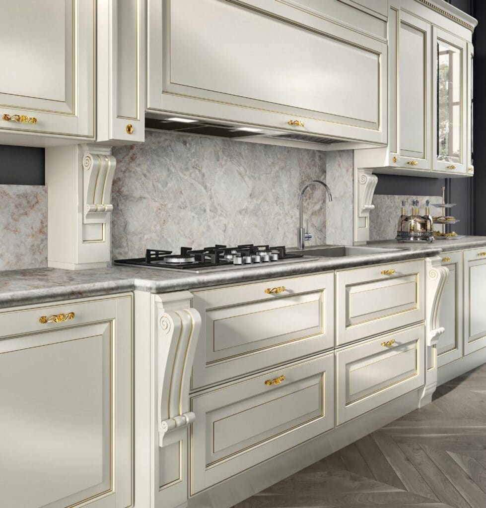 Elegant kitchen with ornate white cabinets, gold accents, a marble backsplash, built-in stovetop, and a modern faucet over a stainless steel sink.
