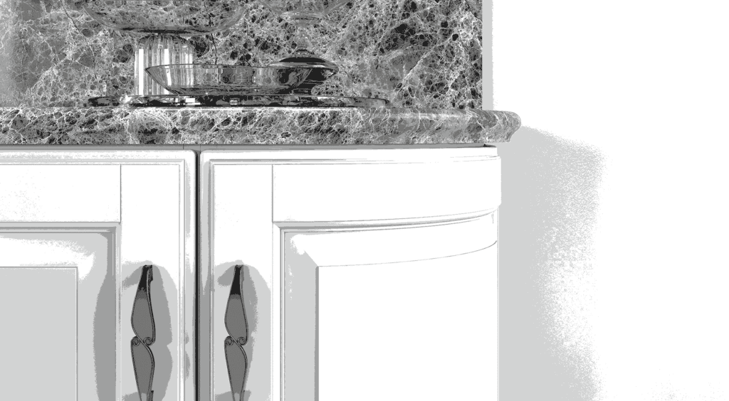 Close-up of a marble countertop with a decorative glass dish and cabinet doors beneath.