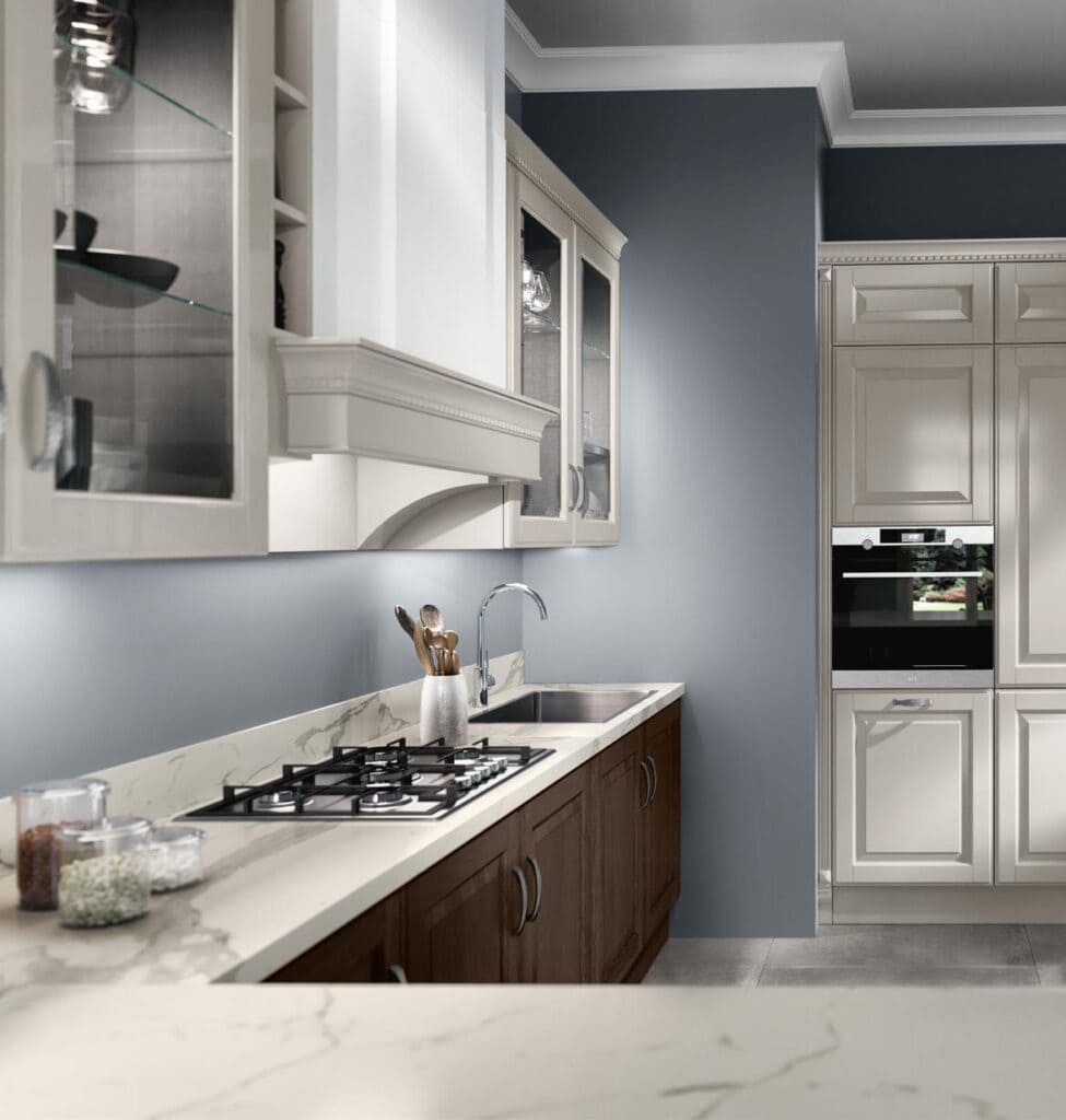 Modern kitchen with marble countertops, gas stove, under-sink wood cabinets, glass-front upper cabinets, and built-in stainless steel appliances.