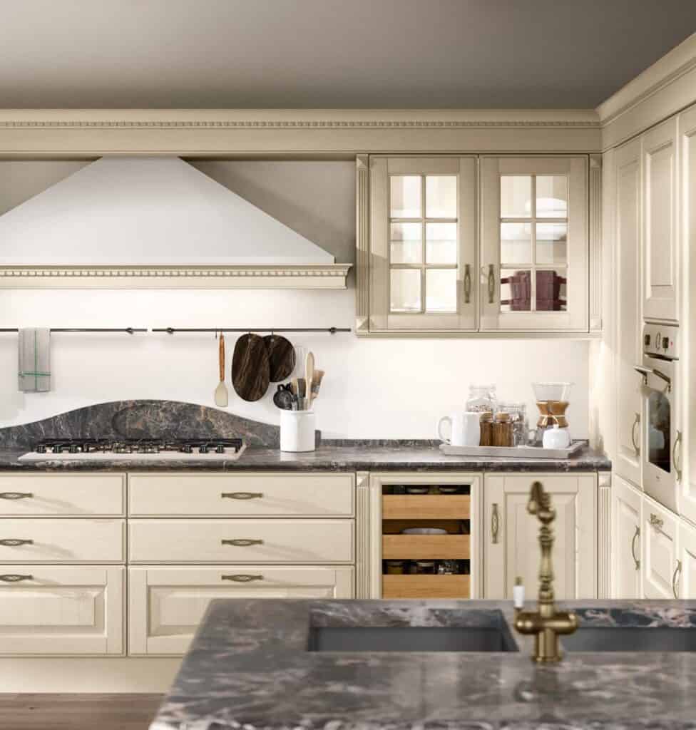 Traditional kitchen with cream cabinetry, marble countertops, and brass fixtures.