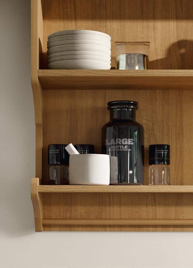 Wooden kitchen shelf with stacked white plates, a reflective glass, a large dark bottle labeled &quot;LARGE,&quot; and small containers.