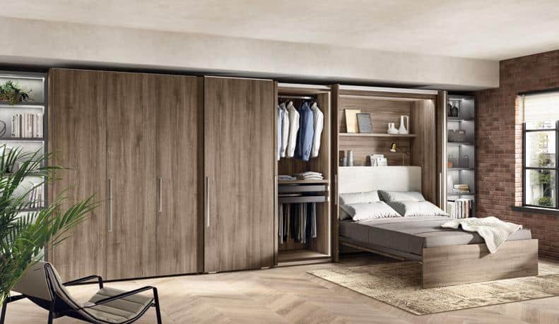 Modern bedroom with a convertible wardrobe that opens into a bed, surrounded by shelves, books, and a chair.
