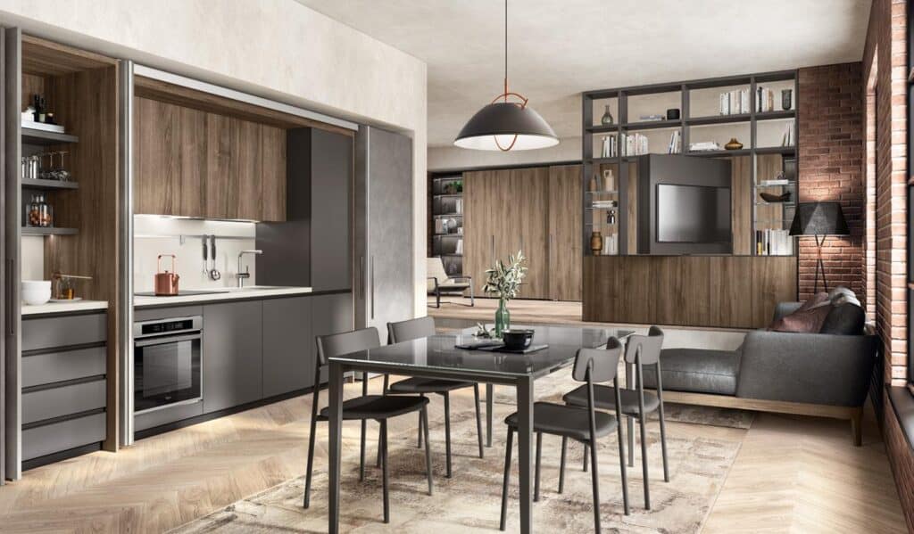 Modern open-plan living space with a sleek kitchen, dining table, gray chairs, sectional couch, and built-in shelving units.