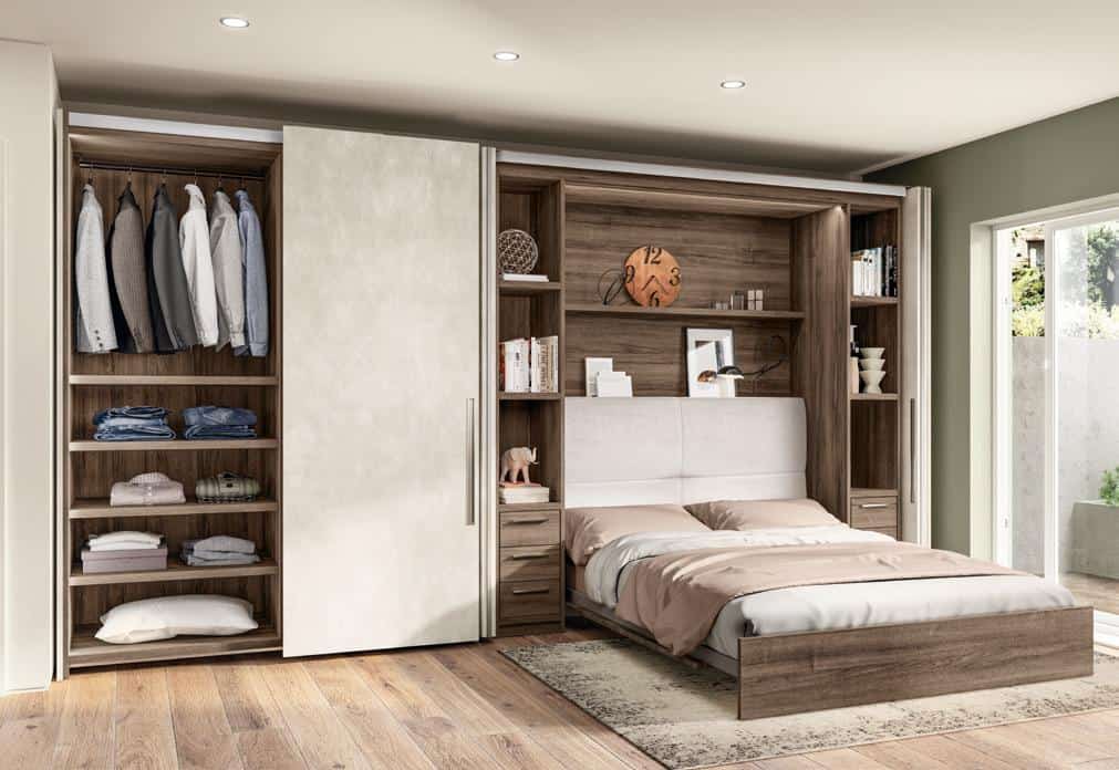 Modern bedroom with an integrated wardrobe and shelving unit, featuring a bed with a wooden frame, neutral bedding, and sliding closet doors.