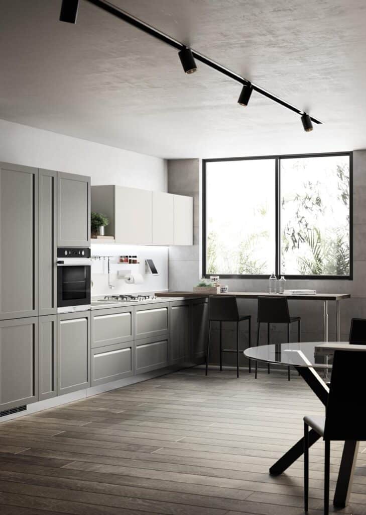 Modern kitchen with gray cabinets, a built-in oven, and a window for natural light.