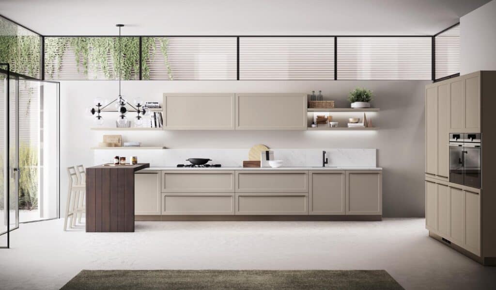 Modern kitchen with beige cabinetry, marble countertops, and a wooden breakfast bar. Vertical windows with blinds and hanging plants add natural light.