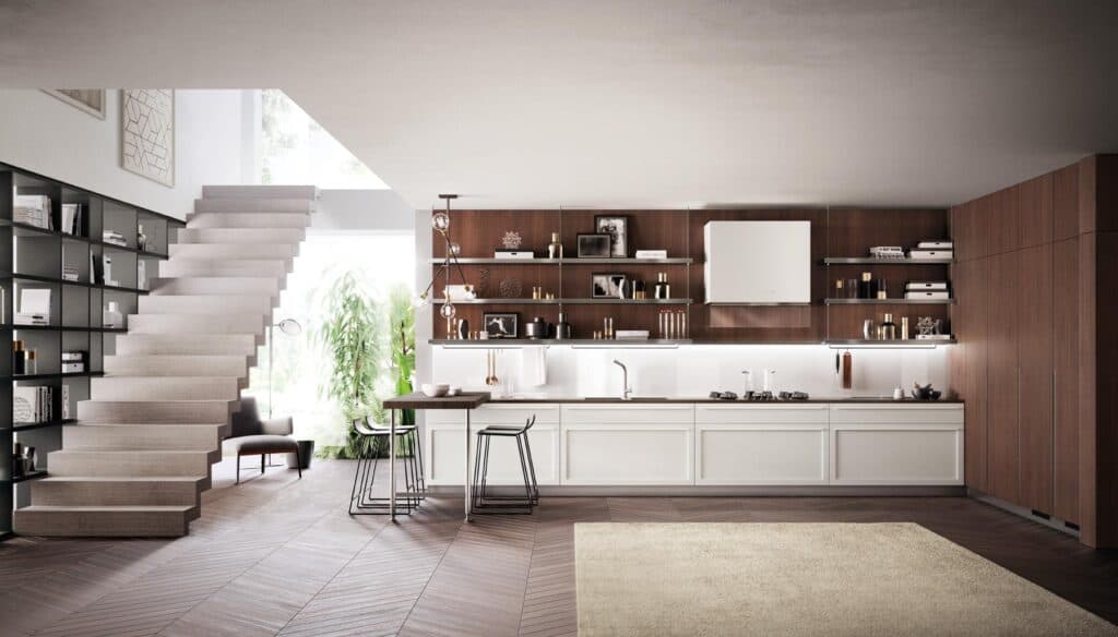 Modern kitchen interior with wooden cabinetry, open shelving, a staircase, and a small dining area with bar stools.