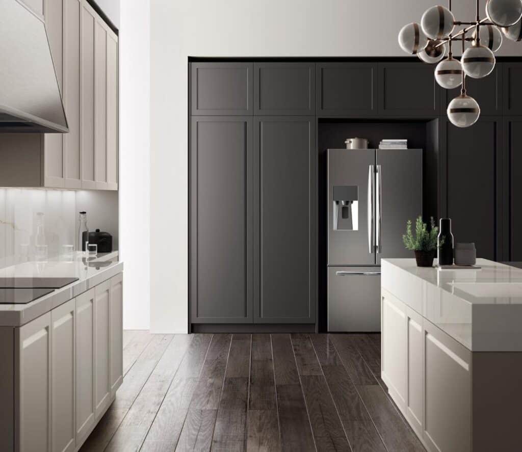Modern kitchen with sleek cabinetry, stainless steel refrigerator, large island with white countertop, and wood flooring.