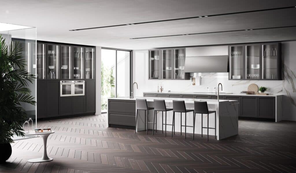 Modern kitchen with dark cabinets, marble countertops, a central island with bar stools, and large windows allowing natural light.
