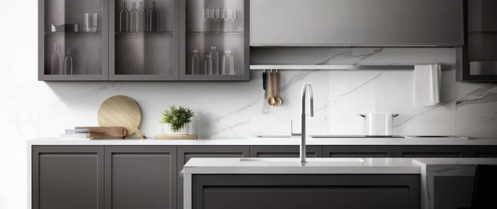 Modern kitchen interior with dark cabinets, marble countertops, a stainless steel faucet, and minimalist decorations.