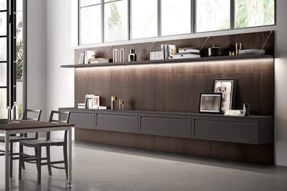 Modern dining area with sleek cabinetry, books, and decorative items under a large window.