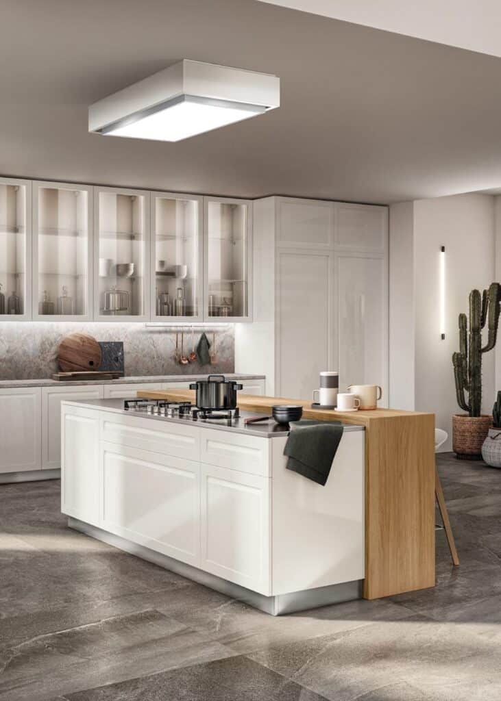 Modern kitchen with white cabinets, a central island with a stove, and countertop accessories.