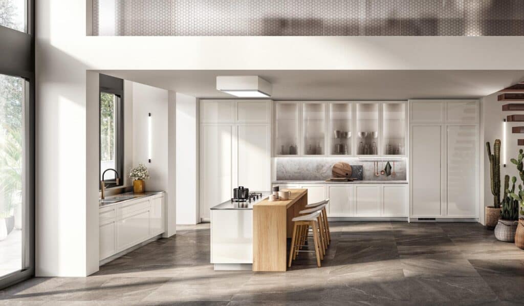 Modern kitchen interior with white cabinets, a central island with wooden accents and bar stools, stainless steel appliances, and large windows.