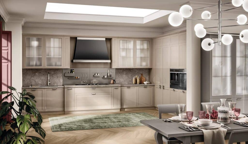Modern kitchen with beige cabinetry, stainless steel appliances, a central skylight, and a dining table set with elegant glassware and dinnerware, complemented by a green rug and contemporary lighting.