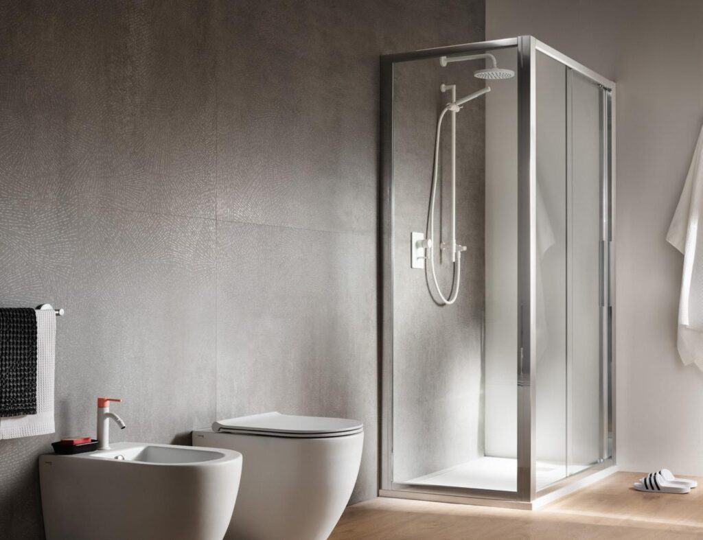 Modern bathroom with a shower enclosure, toilet, bidet, and wall-mounted towel.