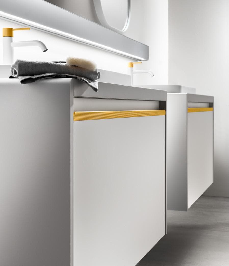 Modern bathroom vanity with white cabinets, yellow accents, and a countertop featuring a sink and faucets.
