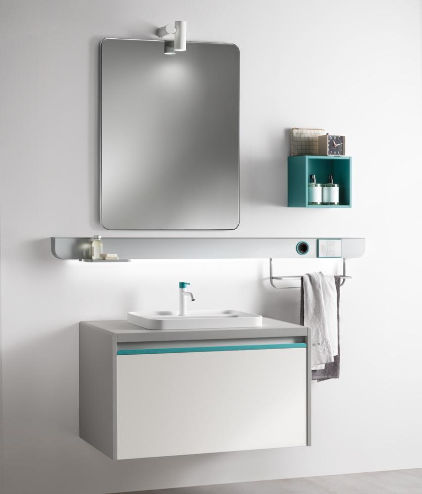 Modern bathroom with a wall-mounted mirror, vanity with a sink, small shelf with toiletries, and a towel rack.