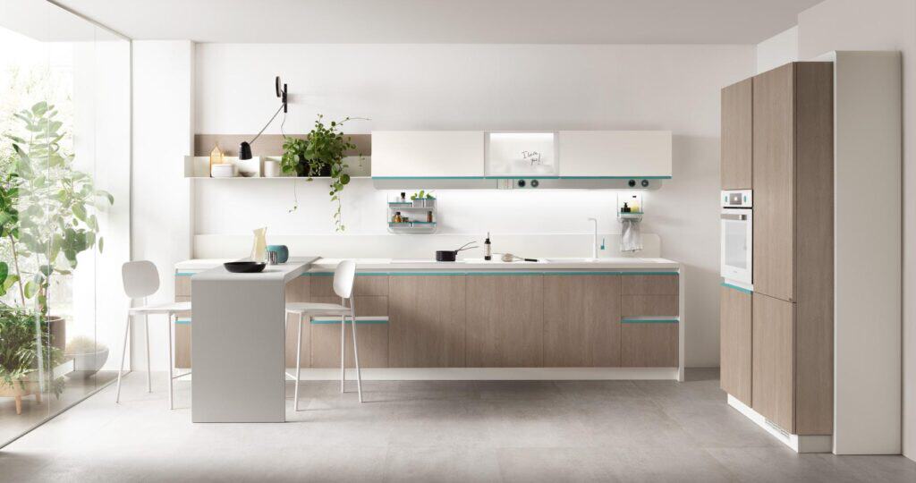 Modern kitchen with light wood cabinets, white countertops, and built-in appliances, featuring potted plants on shelves and a large window letting in natural light.