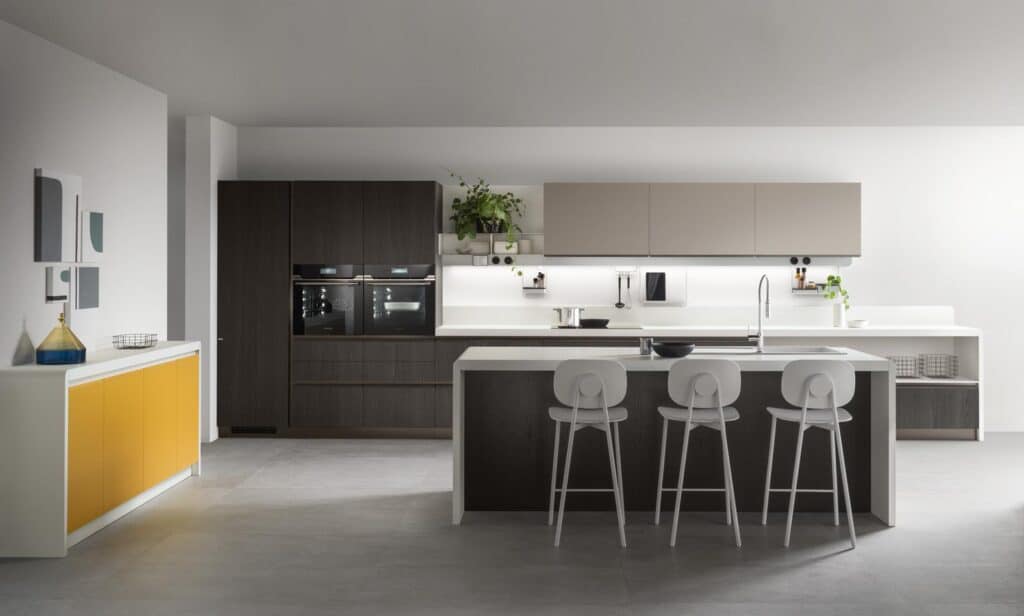 Modern kitchen with a large island, bar stools, built-in appliances, and minimalist decor.