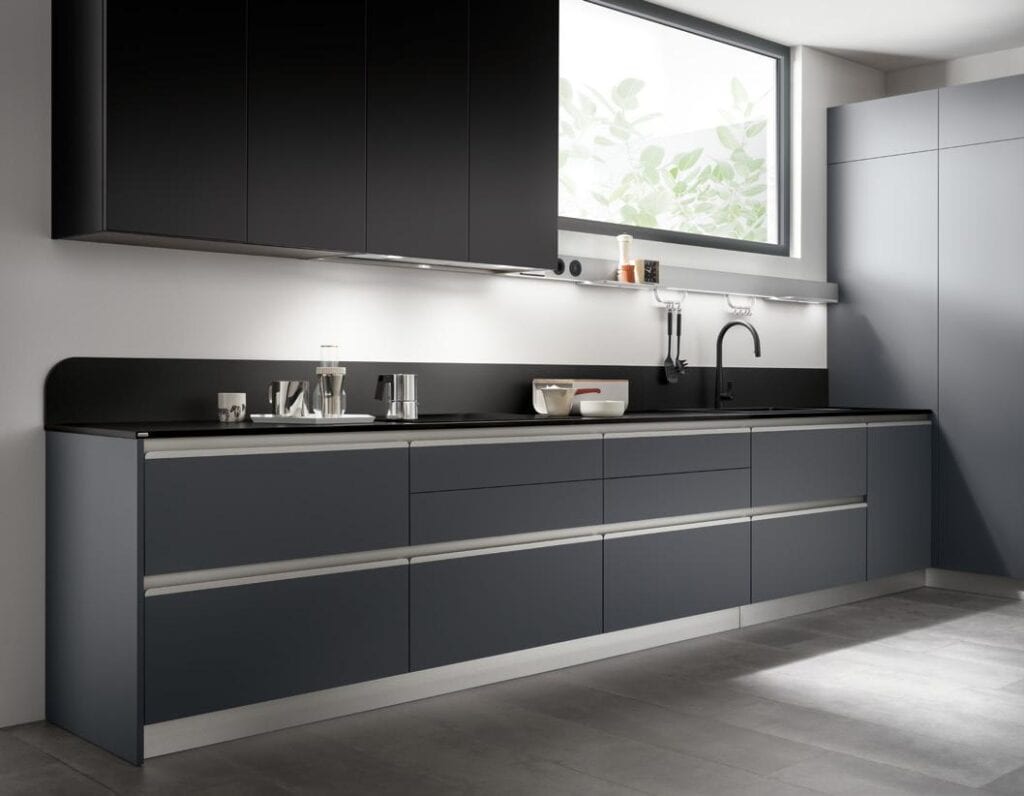 Modern kitchen with dark cabinets, a sleek countertop, and a large window.