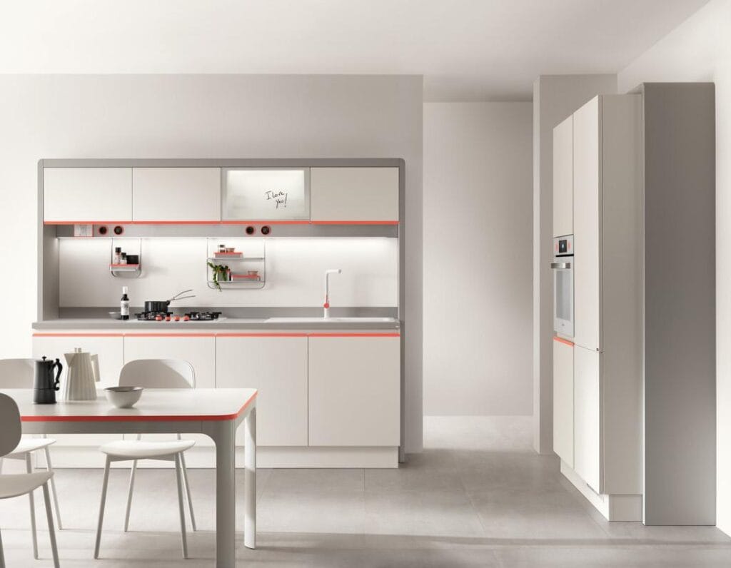 Modern kitchen with white cabinets, a built-in oven, and a central island with a cooktop. There&#039;s a dining table with chairs and minimalistic decor.