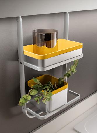 Wall-mounted shelf with yellow and white containers holding plants and a metallic object.