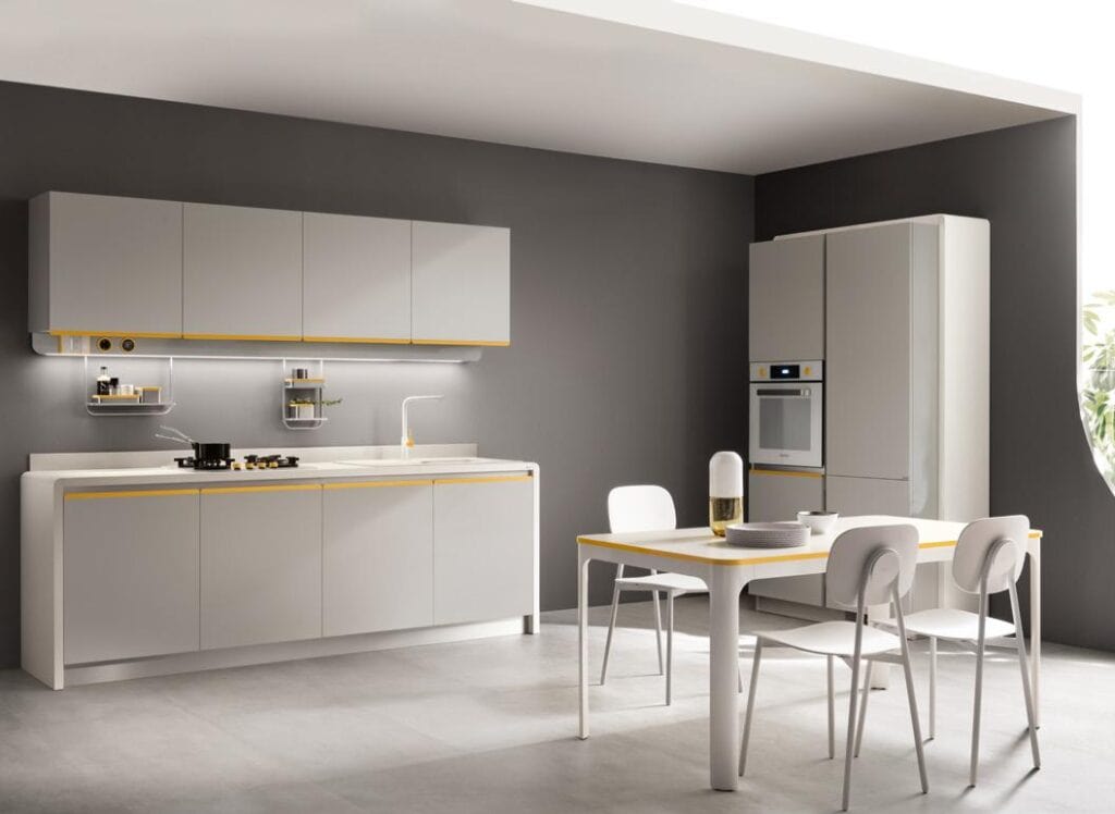Modern kitchen design with white cabinets, a gray accent wall, minimalistic furniture, and built-in appliances.