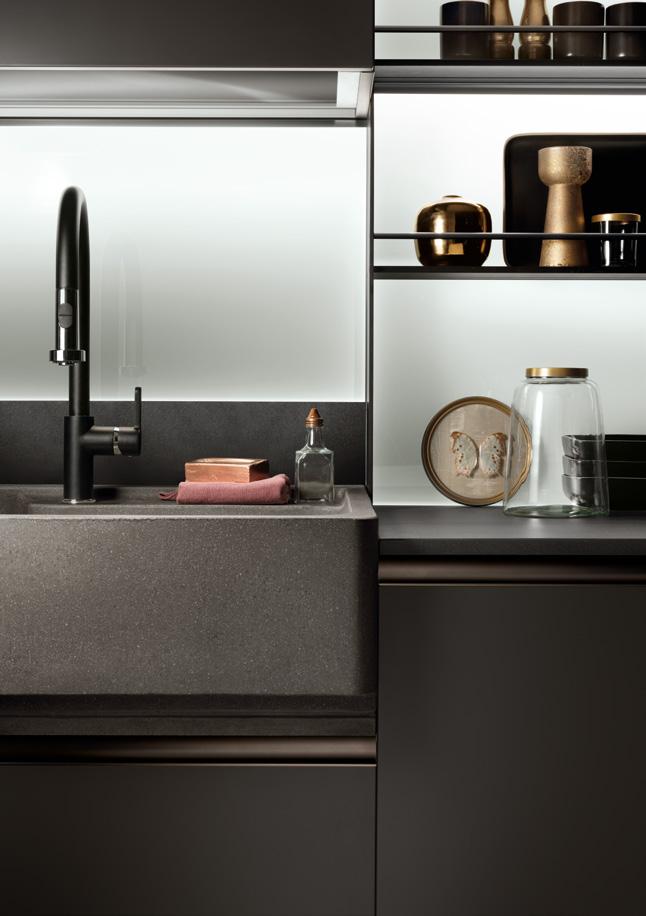 Modern kitchen sink with a dark faucet, countertop, and open shelves displaying decorative items.