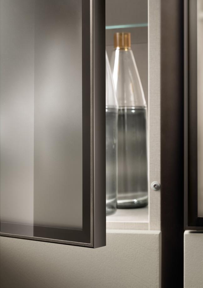Frosted glass cabinet door slightly ajar, revealing bottles inside.