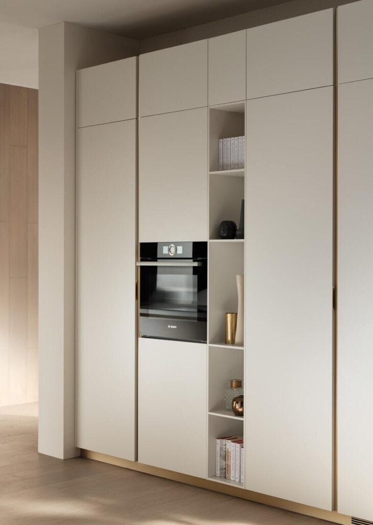 Modern built-in kitchen cabinets with a black Bosch oven and open shelving displaying decorative items and books.