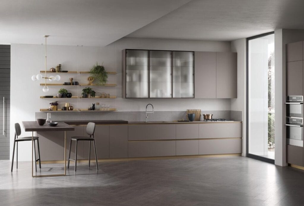 Modern kitchen with gray cabinetry, open wooden shelves, a small dining table with two chairs, pendant lighting, and large windows.