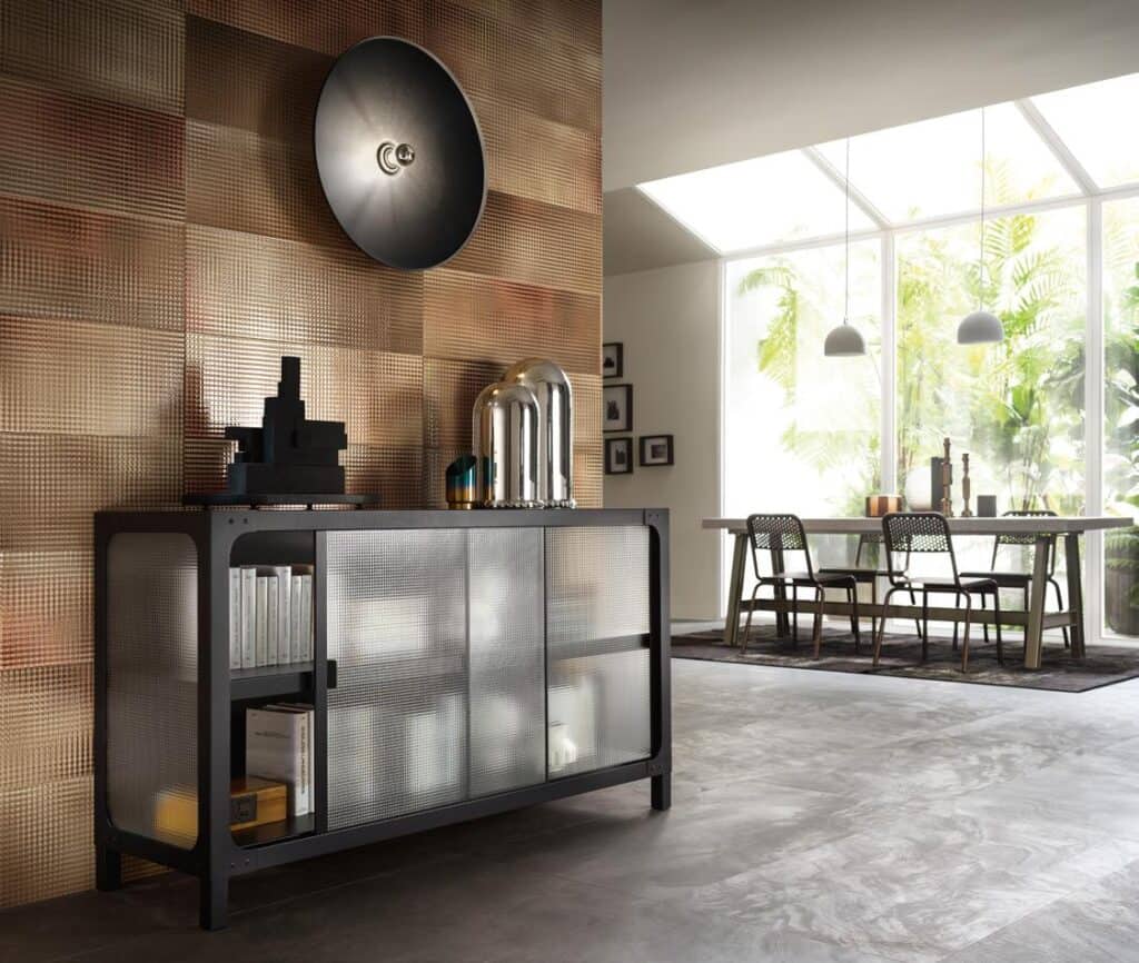 Modern living room interior with a textured wall, frosted glass cabinet, and a dining area with large windows.