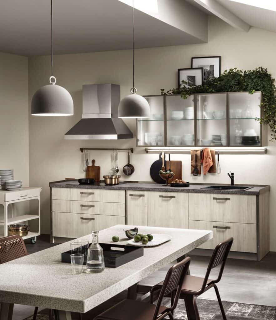 Modern kitchen interior with pendant lights, wooden cabinets, a stone countertop, and a dining table with chairs.