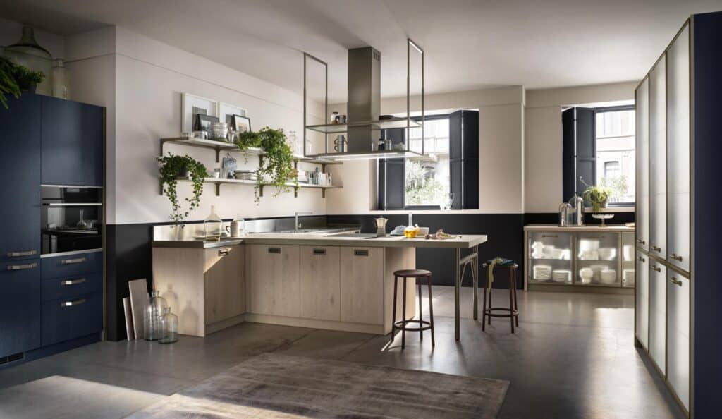 Modern kitchen with U-shaped wooden cabinets, shelf with plants, and hanging hood.