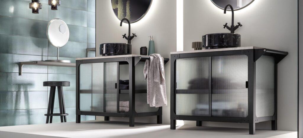 Modern bathroom with two black vanities featuring mesh doors, black vessel sinks, wall-mounted faucets, and round mirrors above.