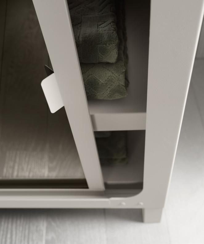 A partially open cabinet door revealing neatly folded green towels inside.
